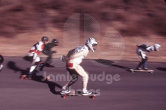 DOWN HILL SKATEBOARD RACERS © Jamie Budge, all rights reserved.
GROUP OF 4 DOWNHILL SKATE RACERS AT FULL SPEED BELOW SIGN ON OLD TUJUNGA CANYON.