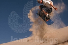 SANDBOARDER SPRAYS SAND © Jamie Budge, All Rights Reserved.
TYLER KENT SPRAYS SAND WHILE CATCHING AIR AT DUMONT DUNES, CA.