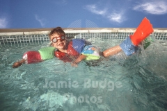 KID FLIPS IN POOL WEARING FULL FLOTATION DEVICES © Jamie Budge, all rights reserved