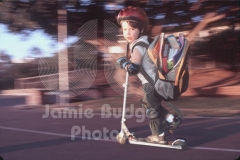 SCOOTER KID WITH OVER-STUFFED BACKPACK © Jamie Budge, all rights reserved